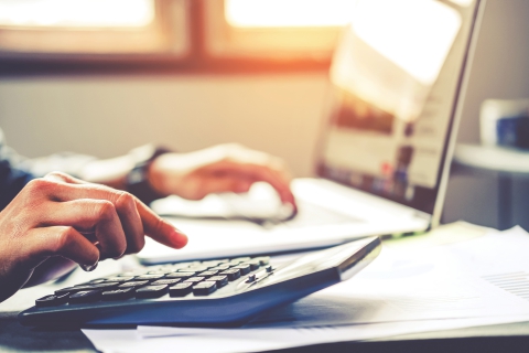 Businessman`s hands with calculator at the office and Financial data Cost Economic.